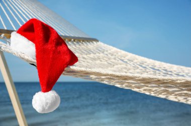 Sahilde Noel Baba 'nın şapkası olan bir hamak, yakın plan. Noel tatili