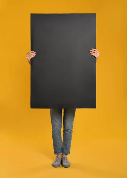 Γυναίκα Κρατώντας Μαύρη Λευκή Αφίσα Στο Κίτρινο Φόντο Mockup Για — Φωτογραφία Αρχείου