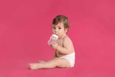 Cute little baby in diaper on pink background clipart