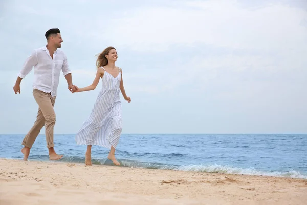 一对快乐的夫妇在海滩上浪漫地散步 案文的篇幅 — 图库照片