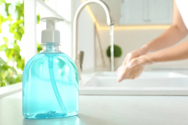 Bir Şişe Antibakteriyel Sabun Arka Planda Ellerini Yıkayan Bulanık Bir — Stok fotoğraf
