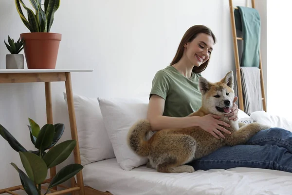 幸せな女性とともに彼女の可愛いです秋田犬子犬で自宅 — ストック写真