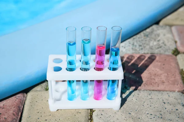 Test tubes with reagents in rack near swimming pool