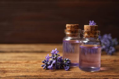 Ahşap masada gerekli yağ ve lavanta çiçekleri. Metin için boşluk