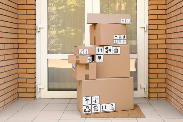 Pappkartonger Med Olika Förpackningssymboler Dörrmattan Nära Entrén Paketleverans — Stockfoto