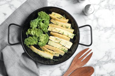 Beyaz mermer masa üzerinde çiğ beyaz havuç ve brokoli ile düz bileşim yatıyordu