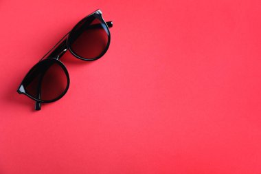 Pembe arka planda şık güneş gözlükleri, üst manzara. Metin için boşluk