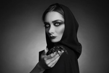 Karanlık arka planda ürkütücü örümceği olan gizemli cadı. Siyah ve beyaz etkisi