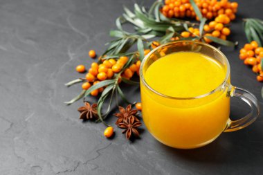 Deniz dikenli çay ve gri masada taze böğürtlen.