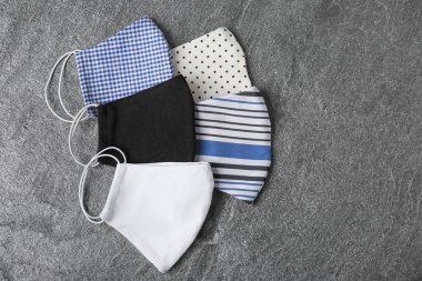 Ev yapımı koruyucu maskeler gri taş masada, düz yerde. Metin için boşluk