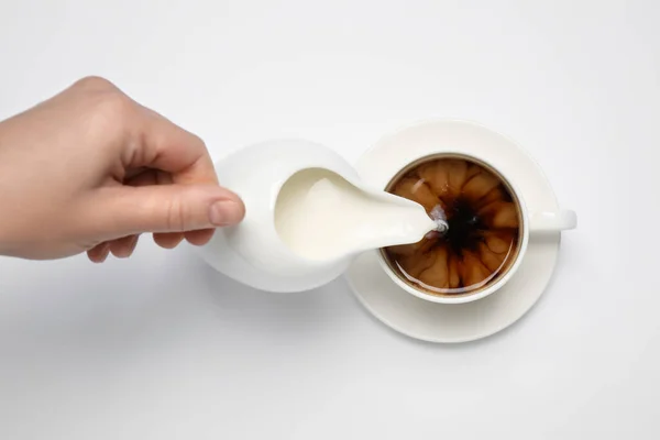 Mujer Vertiendo Leche Taza Café Sobre Fondo Blanco Vista Superior — Foto de Stock