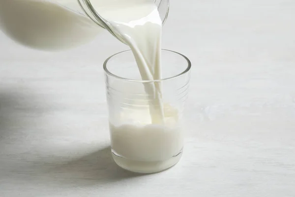 Verser Lait Dans Verre Sur Une Table Blanche — Photo