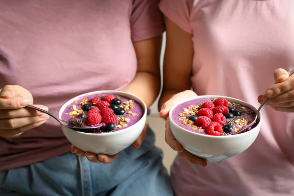 Pai e filho comem sobremesa com sementes de chia e manga à beira da piscina  pela manhã. alimentação saudável, comida vegetariana, dieta e conceito de  pessoas