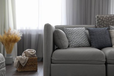 Pencerenin yanında rahat kanepesi olan şık bir oturma odası. İç tasarım