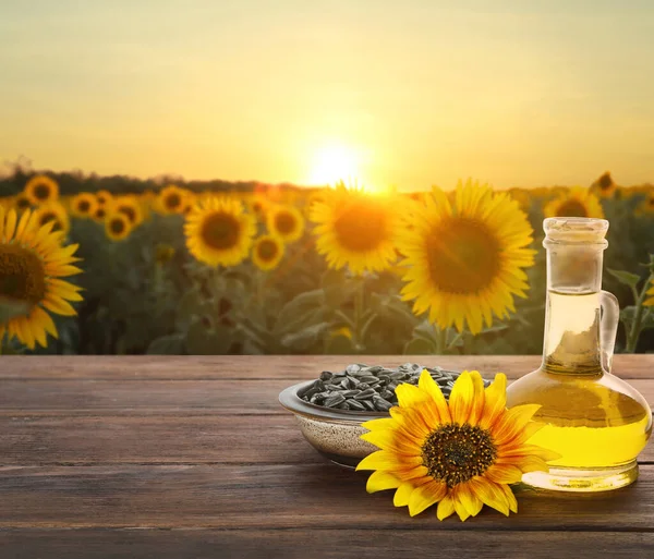 Sonnenblumenöl Und Samen Auf Einem Holztisch Der Nähe Blühender Felder — Stockfoto