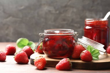 Lezzetli çilek reçeli ve ahşap masada taze böğürtlen.