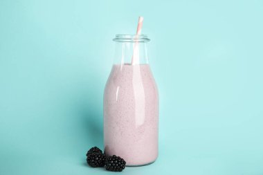 Lezzetli taze milkshake ve açık mavi arka planda böğürtlen