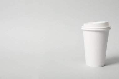 Açık gri arka planda paket kâğıttan kahve fincanı. Metin için boşluk