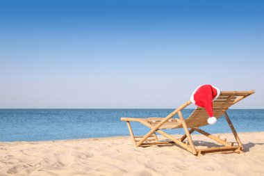 Plajda Noel Baba 'nın şapkasıyla güneşlik, mesaj için yer. Noel tatili