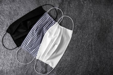 Ev yapımı koruyucu maskeler gri taş masada, düz yerde. Metin için boşluk