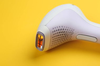 Sarı arkaplanda modern fotoepilatör, yakın plan görünümü