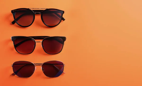 Wiele Stylowych Okularów Przeciwsłonecznych Pomarańczowym Tle Płaskie Leżały Miejsce Tekst — Zdjęcie stockowe