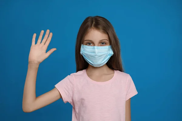 Little Girl Protective Mask Showing Hello Gesture Blue Background Keeping — Stock Photo, Image