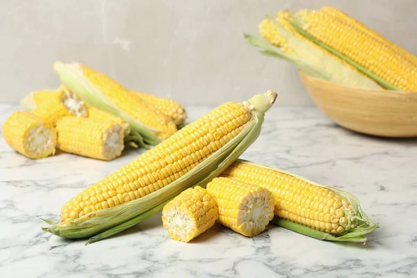 Bunch of corn cobs on white marble table