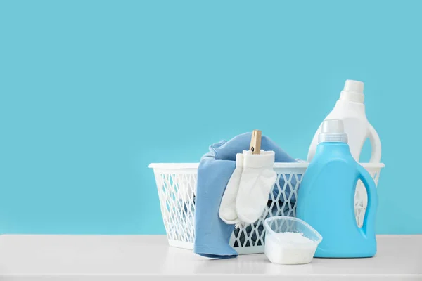 Waschmittel Und Kinderkleidung Auf Weißem Tisch Neben Hellblauer Wand Raum — Stockfoto