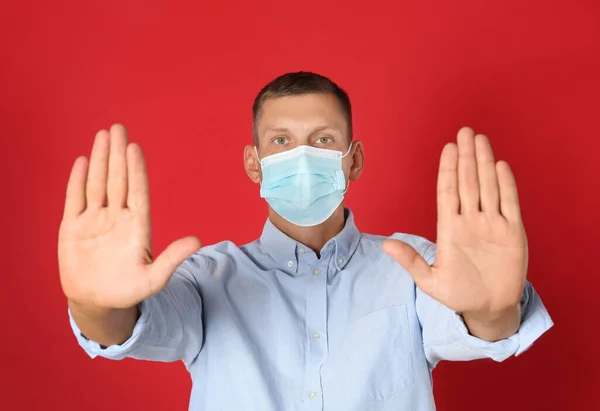 Man Skyddsmask Visar Stop Gest Röd Bakgrund Förhindra Spridning Coronavirus — Stockfoto