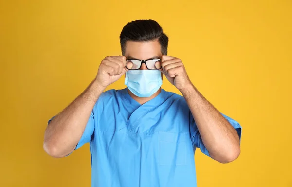 Dottore Pulire Vetri Nebbiosi Causati Indossare Maschera Medica Sfondo Giallo — Foto Stock