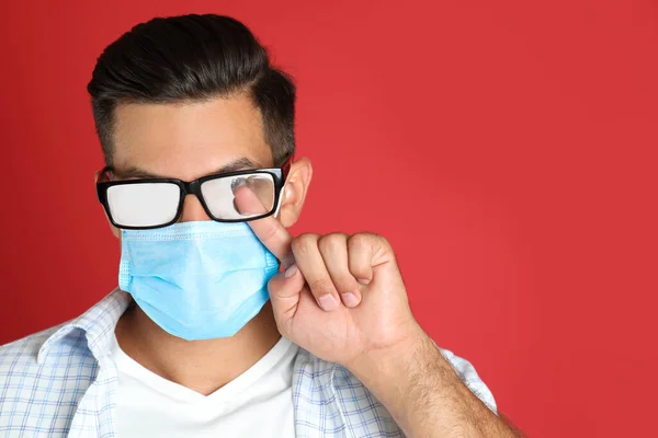 Man Wiping Foggy Glasses Caused Wearing Medical Mask Red Background — Stock Photo, Image