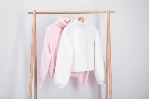 Stylish Knitted Sweaters Hanging Clothing Rack Light Wall — Stock Photo, Image