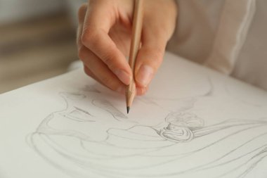 Woman drawing girl's portrait with pencil on sheet of paper, closeup clipart