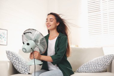Hayranı olan bir kadın evde hava akımının keyfini çıkarıyor. Yaz sıcağı