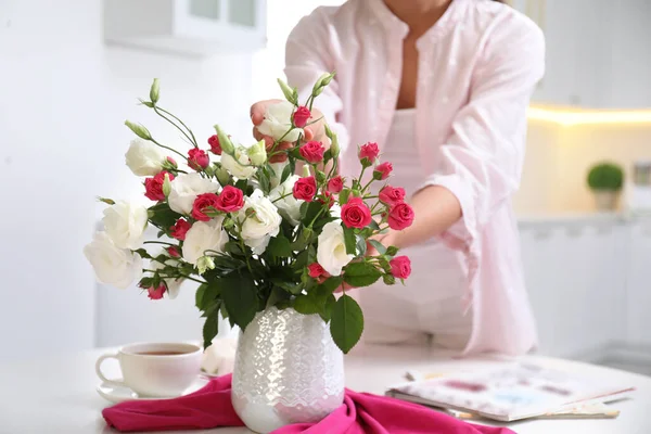 テーブルの上のおしゃれな花瓶に新鮮な花の花束を持つ女性 クローズアップ — ストック写真