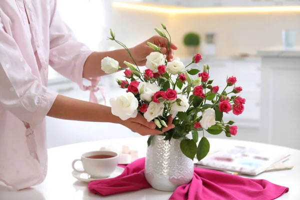 テーブルの上のおしゃれな花瓶に新鮮な花の花束を持つ女性 クローズアップ — ストック写真