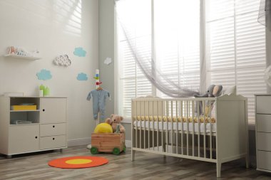 Bebek odasının içinde beşik ve oyuncaklar var.