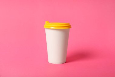 Pembe arka planda paket kağıttan kahve fincanı.