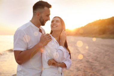 Mutlu genç çift gün batımında sahilde