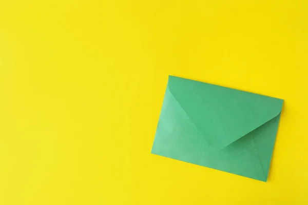 黄色の背景に緑の紙の封筒 トップビュー テキストのスペース — ストック写真