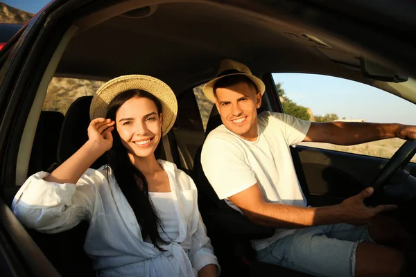 Happy couple in car on road trip