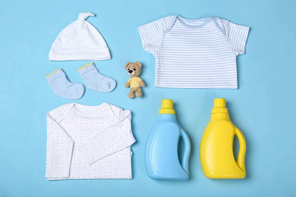薄い青の背景に洗剤と子供服のボトルとフラットレイアウト組成物 — ストック写真