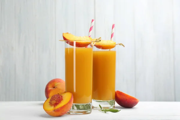 天然桃ジュースと白木のテーブルの上の新鮮な果物 — ストック写真