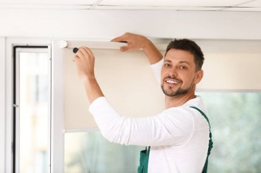 Tornavidalı tamirci içeride paten penceresi kuruyor.