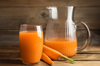 Sürahi ve taze yapılmış havuç suyu ahşap masada.