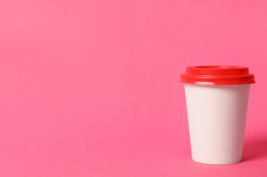 Pembe arka planda paket kağıttan kahve fincanı. Metin için boşluk