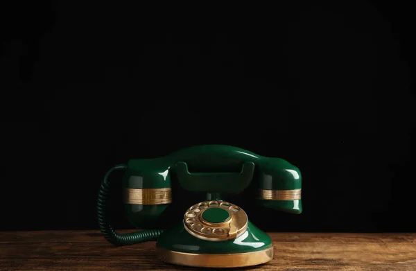 Vintage Telefoon Met Snoer Houten Tafel Tegen Zwarte Achtergrond — Stockfoto