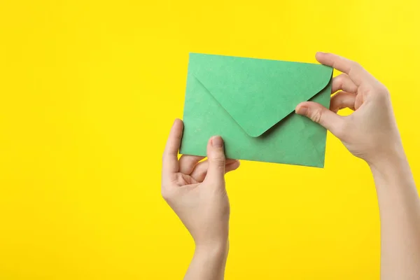 Woman Holding Green Paper Envelope Yellow Background Closeup — Stock Photo, Image
