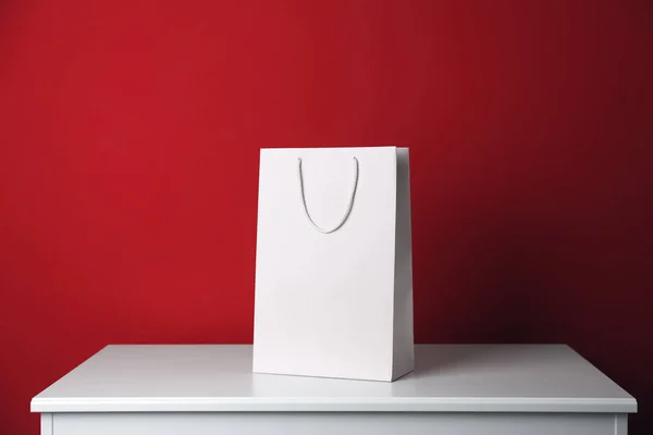 Bolso Compras Papel Sobre Mesa Blanca Sobre Fondo Rojo — Foto de Stock